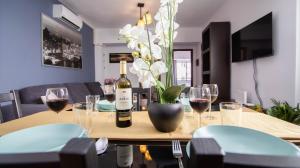 una mesa con una botella de vino y copas de vino en Bonito apartamento zona Weyler en Santa Cruz de Tenerife