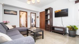 a living room with a couch and a tv at Bonito apartamento zona Weyler in Santa Cruz de Tenerife