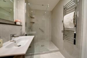 a white bathroom with a sink and a shower at TALLEST BUILDING IN THE CITY CENTRE SLEEPS 5 incredible city mountain and Lagan views in Belfast