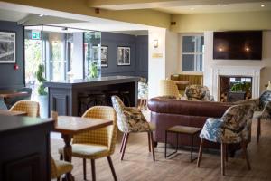 a living room with a couch and tables and chairs at Best Western Gables Hotel in Falfield