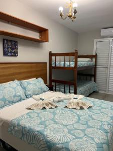 a bedroom with a bed with two bunk beds at Pousada Praia Grande in Ubatuba