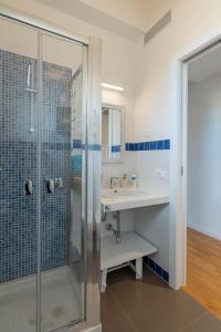 une salle de bain avec douche et lavabo dans l'établissement La Casa degli Ulivi appartamento in villa con patio, à Quartu SantʼElena