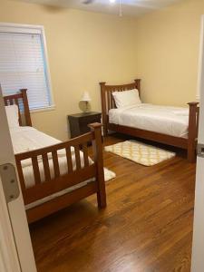 two beds in a room with wood floors and a window at Beautiful Home Near Braves stadium&Atl united Fc in Marietta