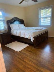 een slaapkamer met een groot bed met een houten hoofdeinde bij Beautiful Home Near Braves stadium&Atl united Fc in Marietta