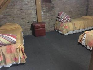 Pokój z 2 łóżkami i ceglaną ścianą w obiekcie Hermosa cabaña con vista a la montaña w mieście Tunuyán