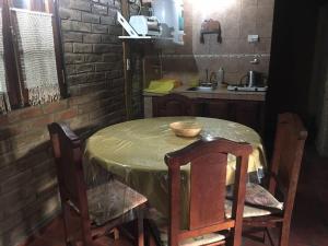 cocina con mesa con sillas y fregadero en Hermosa cabaña con vista a la montaña en Tunuyán