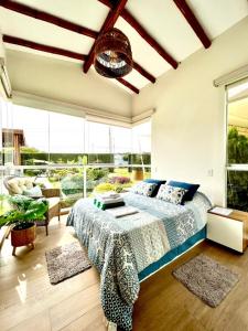 een slaapkamer met een bed en grote ramen bij Kuyayky Lodge in Lima