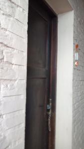 une porte brune dans un mur de briques blanches dans l'établissement Coralca, à Martínez