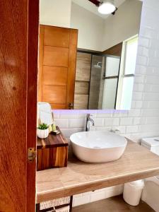 een badkamer met een grote witte wastafel en een spiegel bij Kuyayky Lodge in Lima
