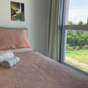 ein Bett mit zwei Handtüchern darauf neben einem Fenster in der Unterkunft Flat Muro Alto Porto de Galinhas in Porto De Galinhas