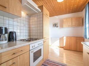 a kitchen with wooden cabinets and a stove top oven at Haus Sporer in Gerlosberg