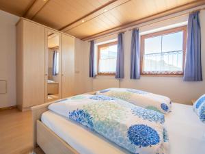 1 dormitorio con 1 cama con almohadas azules y blancas en Haus Rieder en Gerlosberg