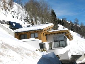 una casa en la cima de una ladera cubierta de nieve en Apart Altavista, en Kappl