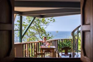 a woman sitting at a table on a balcony at Hotel Kambutaleko in Cambutal +42 photos