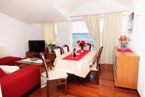 a living room with a table and a red couch at Apartments with a parking space Zavala, Hvar - 8773 in Zavala
