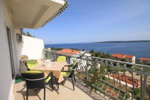 a balcony with a table and chairs and a view of the water at Apartments with a parking space Zavala, Hvar - 8773 in Zavala