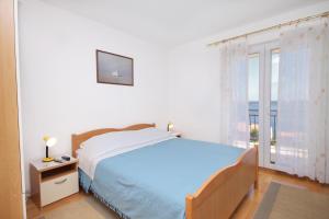 a bedroom with a bed and a large window at Apartments with a parking space Zavala, Hvar - 8773 in Zavala