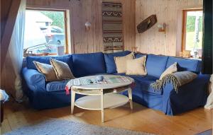 um sofá azul numa sala de estar com uma mesa em Cozy Home In Strmsund With Lake View em Strömsund