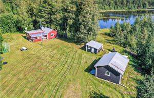uma vista aérea de uma casa num campo ao lado de um lago em Cozy Home In Strmsund With Lake View em Strömsund