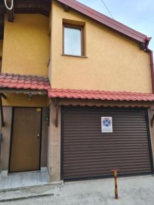 un edificio con due porte garage con un cartello sopra di Apartman Yellow House a Sarajevo