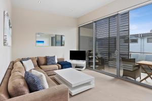 a living room with a couch and a tv at OG- By the Sea, 400m to Beach in Ocean Grove