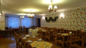 uma sala de jantar com mesas e cadeiras e papel de parede floral em Ośrodek Wypoczynkowy "Hotel Korona" em Mostowice