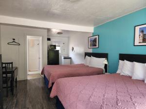 a hotel room with two beds and a table at Plainview Motel in Coos Bay