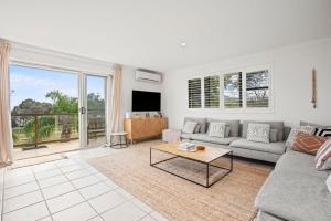 a living room with a couch and a table at Lawson Beachfront in Byron Bay