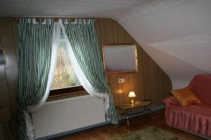 ラールにあるFerienwohnung Am Altenbergの窓とソファ付きの屋根裏部屋