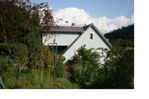 une maison blanche au milieu d'un jardin dans l'établissement Ferienwohnung Am Altenberg, à Lahr/Schwarzwald