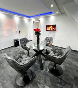a room with a table and chairs and a vase of roses at Phöenixpalace Whirlpool & Infarotsauna in Dortmund +1 photo