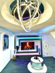a living room with a fireplace and a chandelier at Phöenixpalace Whirlpool & Infarotsauna in Dortmund