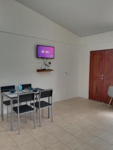KAPALIZ في Tigre: غرفة مع طاولة وكراسي وتلفزيون على الحائط
