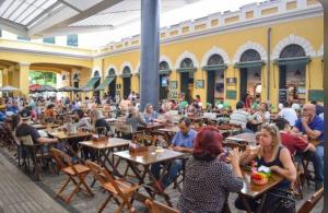 a group of people sitting at tables in a restaurant at Apartamento a poucos minutos do Aeroporto de Floripa e das Praias do Sul da Ilha in Florianópolis