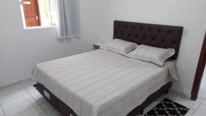 a bed in a white room with a bed sidx sidx sidx at Apartamento a poucos minutos do Aeroporto de Floripa e das Praias do Sul da Ilha in Florianópolis