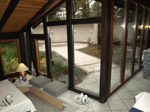 ein leeres Zimmer mit Blick auf den Pool durch die Fenster in der Unterkunft L'Auberge in Walldorf