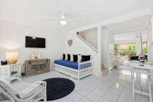 a bedroom with a blue bed and a living room at Eastpoint 3 in Byron Bay