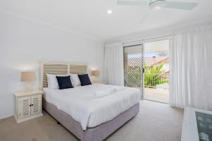 a white bedroom with a large bed and a window at Eastpoint 3 in Byron Bay