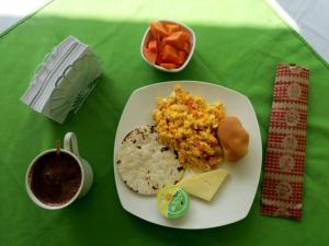 a plate of food with rice and vegetables on a table at Hostal y Camping Los Girasoles in Salento