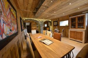 - une salle à manger avec une table et des chaises en bois dans l'établissement La Maison de Dolphe Chalet de Charme & Art gallery, à Brusson