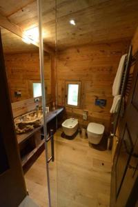 La salle de bains en bois est pourvue de toilettes et d'un lavabo. dans l'établissement La Maison de Dolphe Chalet de Charme & Art gallery, à Brusson