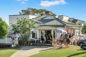 a group of people sitting outside of a house at Ardem at Byron in Byron Bay