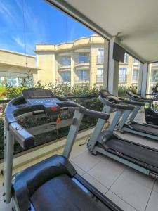 - une salle de sport avec 2 tapis de course devant un bâtiment dans l'établissement Aldeia das Águas Park Resort - Flat B309 Quartier, à Barra do Piraí