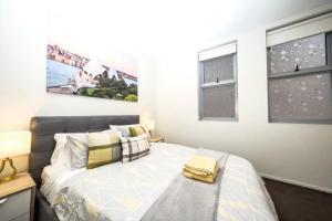 a bedroom with a bed and two windows at Alora Apartment in Sydney CBD - Darling Harbour in Sydney
