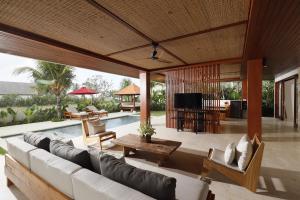 a living room with a couch and a table at Amarta Beach Retreat by Nakula in Tabanan +116 photos