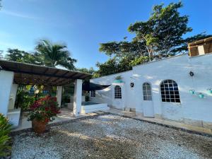 a white house with a porch and a courtyard at Cabaña Doradal MILOS in Puerto Triunfo