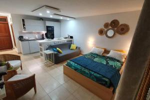 a bedroom with a bed and a small kitchen at U Are We R St Martin Studio Cosy Marigot, Wi-Fi ,Piscine in Marigot