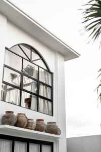 ein Fenster an einer Wand mit Töpfen auf einem Regal in der Unterkunft Villa Medina Canggu in Canggu