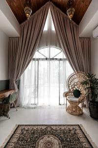 Zimmer mit einem großen Fenster mit einem Stuhl und einem Teppich in der Unterkunft Villa Medina Canggu in Canggu