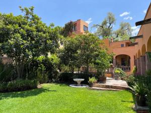 a yard with green grass and a building at Cousy Condo in the historic center of San Miguel de Allende, incredible view, pool, BBQ, 3 blocks from the main parish in San Miguel de Allende